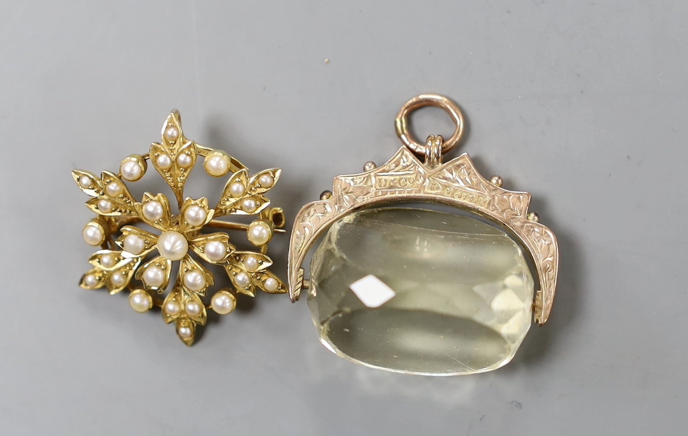 An Edwardian yellow metal and seed pearl cluster set pendant brooch, 27mm, a George V 9ct gold mounted citrine spinning fob, one other gilt metal fob and a damaged locket.